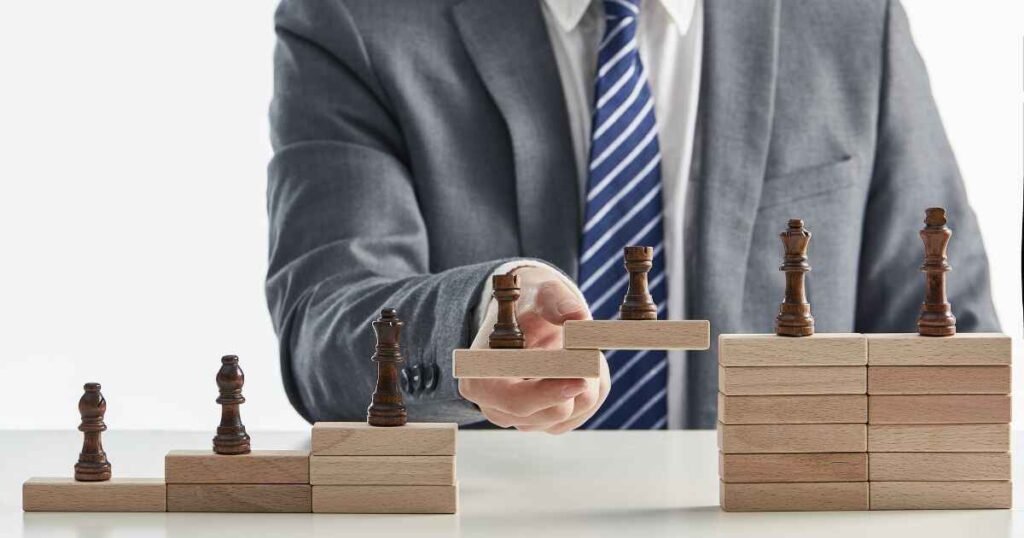 A business person's hands arranging chess pieces on wooden blocks to form a strategic staircase, illustrating the strategic planning and roadmap development provided by AI Consulting Services.